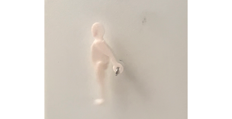 Unscharfe Seitenansicht einer kleinen, hellen menschlichen Figur vor weißem Hintergrund, die sich um ihre eigene Achse dreht.